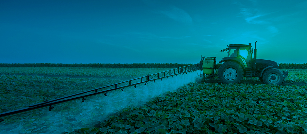 Tractor spraying pesticides on vegetable field with sprayer at spring